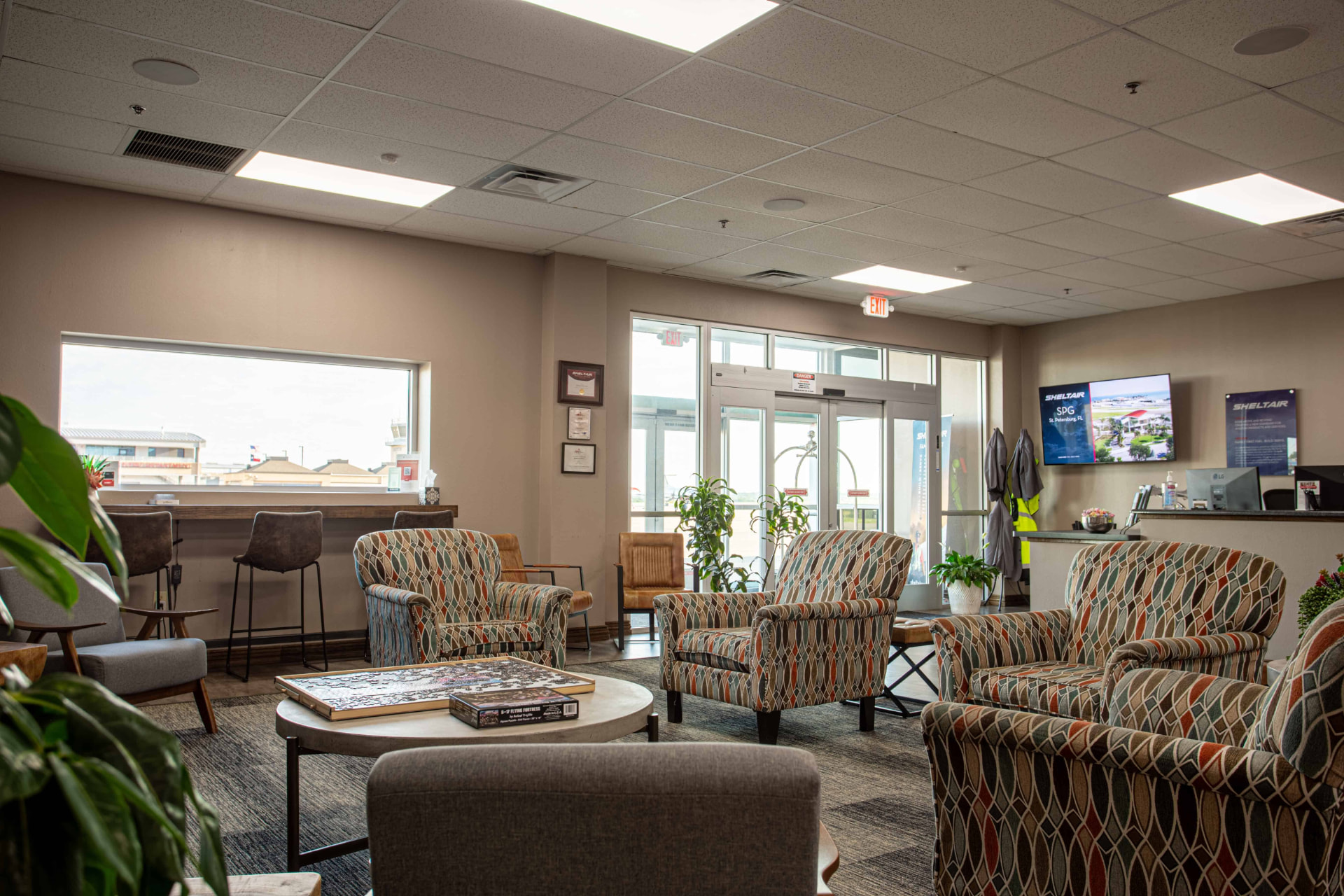 Sheltair pilot lounge with ramp-view window seating and the front desk