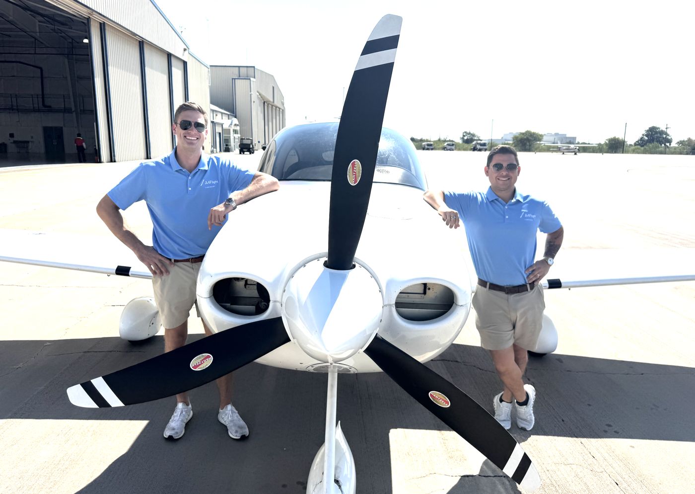 Two A4Flight team members standing in front of a Cirrus SR20 propeller