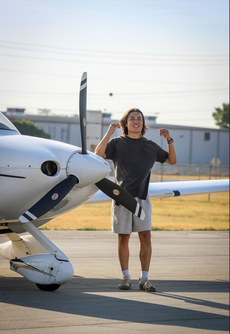 Pilot standing beside a Cirrus propeller at sunset