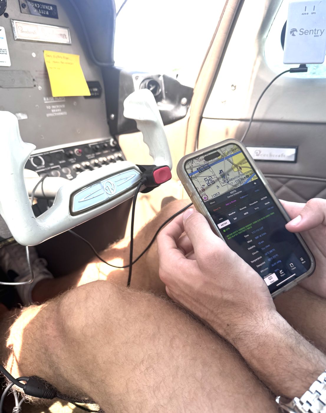 Round-dial instrument panel with a phone running a flight app mounted ahead of it